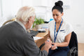 Female doctor using oximeter on senior patients finger in office