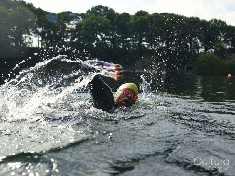 Woman in swimming cap and goggles swimming in river