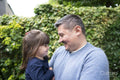Smiling man holding daughter outdoors