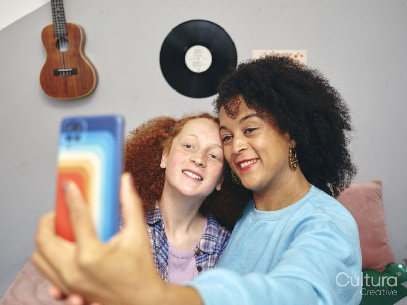 Mother and daughter taking selfie with smart phone