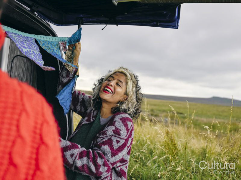 Smiling woman hanging decorations in van