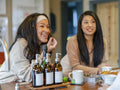 Female friends talking and eating in kitchen