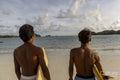 Indonesia, Lombok, Rear view of surfers looking at sea from beach