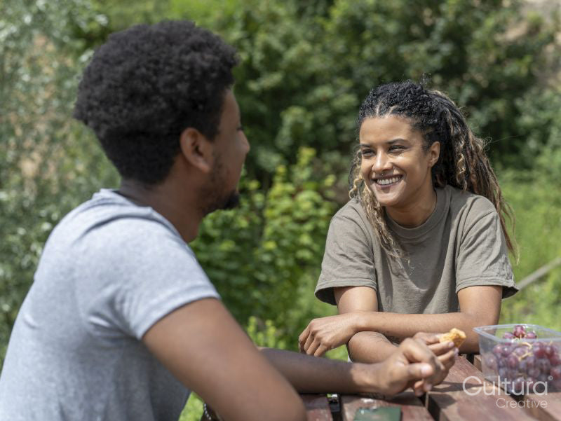 Friends eating snacks by picnic table