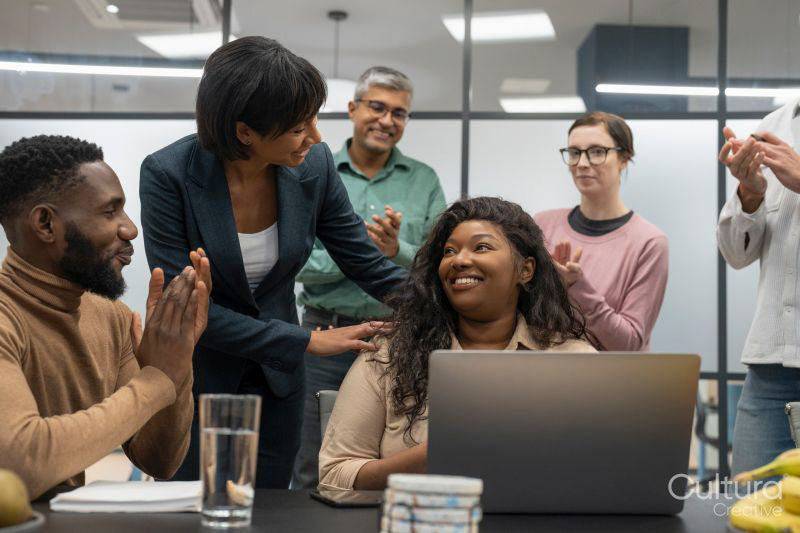 Business people applauding colleague in office