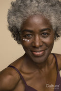 Studio portrait of senior woman with eye cream dots