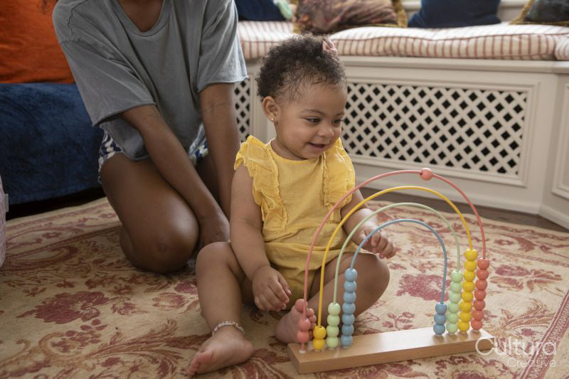 Mother playing with baby daughter at home