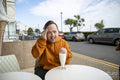 Man drinking milkshake in sidewalk cafe, portrait