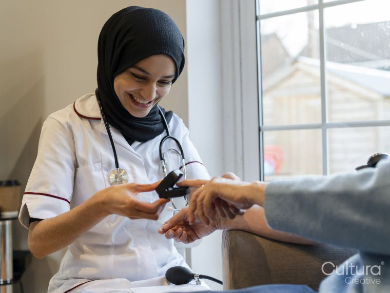 Doctor using pulse oximeter on patient