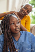 Mother braiding hair for daughter