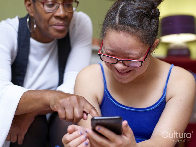 Mother and daughter with Down syndrome using smart phone