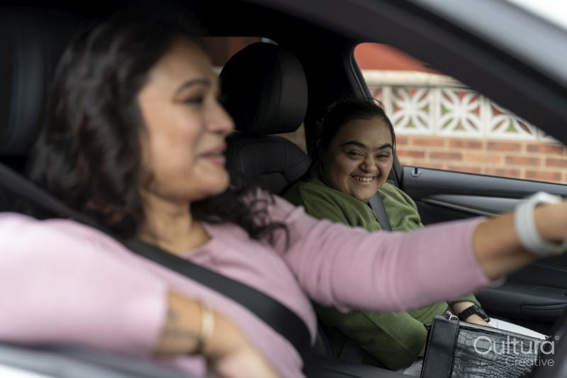 Mother driving car with down syndrome daughter