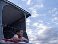 Boy in camper van rooftop tent