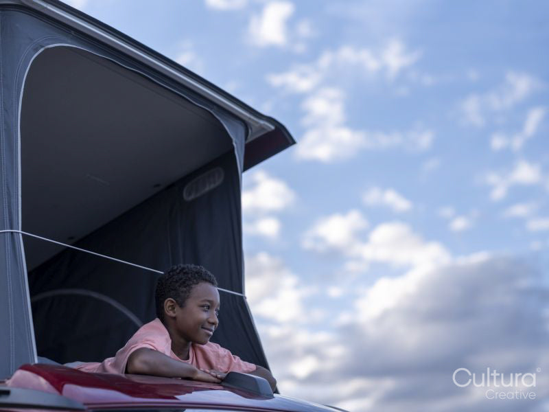 Boy in camper van rooftop tent