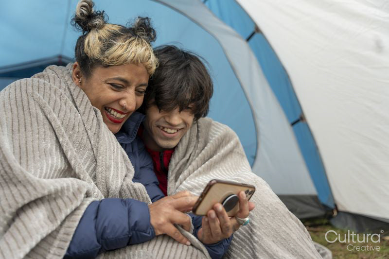 Mother and son using phone in tent