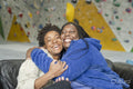 Portrait of mother with daughter embracing in front of climbing wall