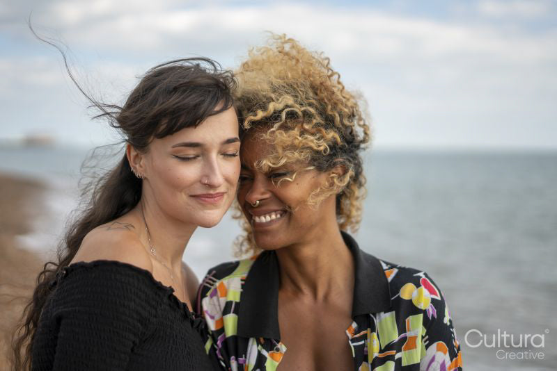 Female couple being close on beach