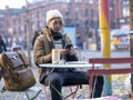 Man using smart phone while sitting at sidewalk cafe