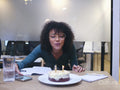 Woman blowing birthday candles in office