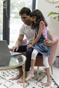 Father sitting with daughter and using laptop
