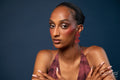 Woman in a burgundy dress and red earrings on a blue background