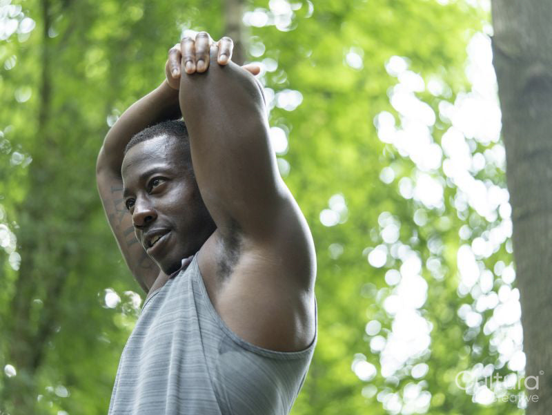 Man stretching after workout in forest