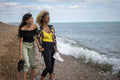 Female couple walking on beach
