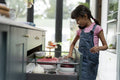 Little girl taking mug from drawer in kitchen