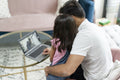 Father sitting with daughter and using laptop