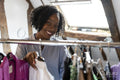 Smiling fashion designer looking at clothes
