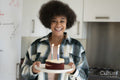 Smiling woman carrying birthday cake
