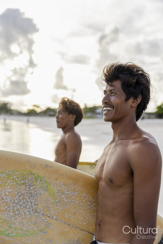 Indonesia, Lombok, Smiling surfers looking at sea from beach