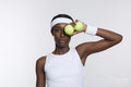 Studio portrait of athletic woman with tennis balls