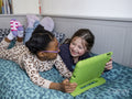 Girl friends using digital tablet at home