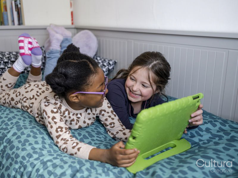 Girl friends using digital tablet at home