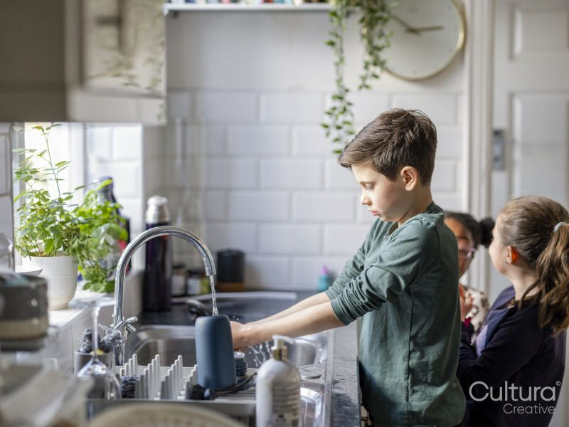 Children washing hands in kitchen sink