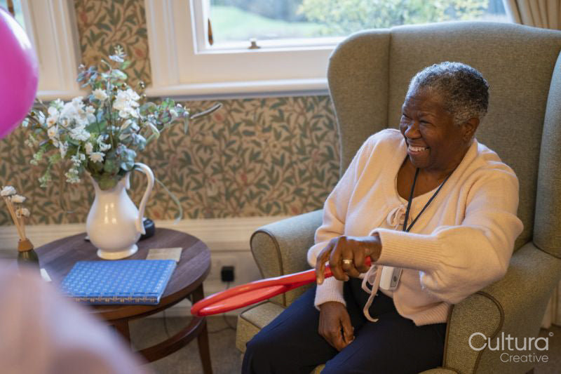 Smiling senior woman playing with racket in nursing home