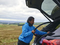 Woman taking bicycle wheel out of car trunk