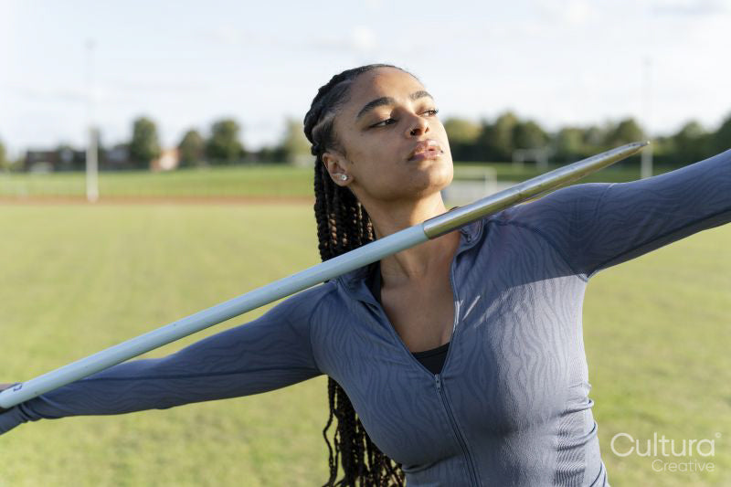 Portrait of female athlete throwing javelin