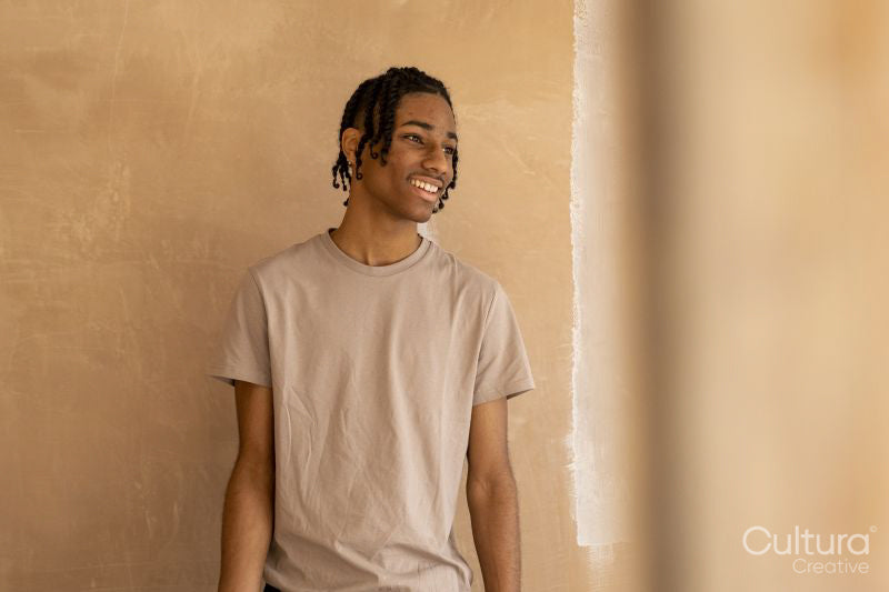 Smiling teenage boy at freshly painted wall in house