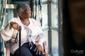 Senior woman with walking cane looking through window