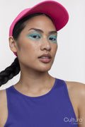 Portrait of woman wearing blue makeup and sun visor