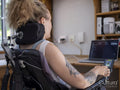 Woman in electric wheelchair working on laptop