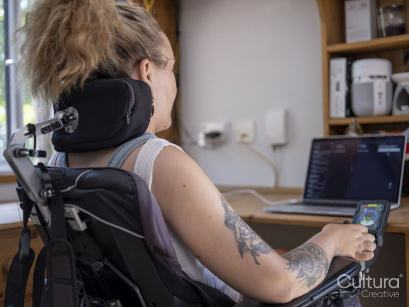 Woman in electric wheelchair working on laptop