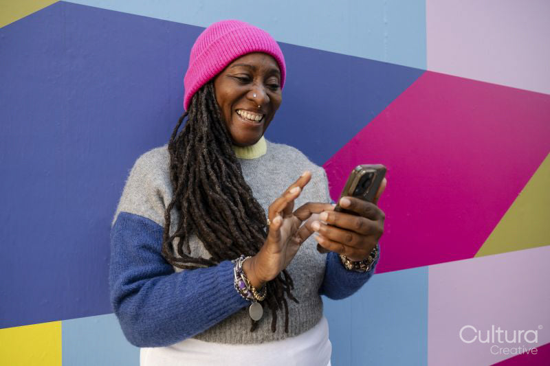 Beautiful woman using phone on colorful background