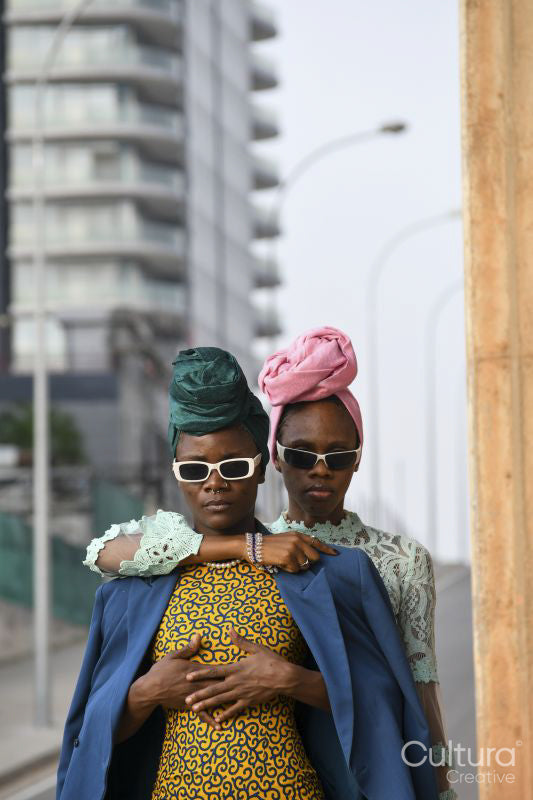 Fashion portrait of two women standing in urban street