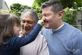 Smiling senior man with son and granddaughter outdoors