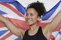 Studio portrait of smiling athletic woman holding British flag