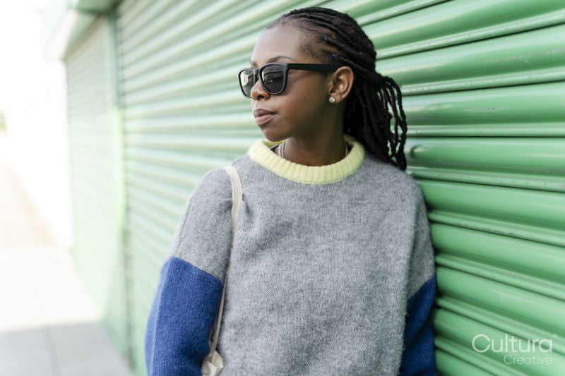 Young stylish woman leaning against green door
