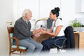 Smiling female doctor holding senior patients hand in office